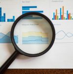 pexels-photo-7947669-7947669 A magnifying glass focuses on various business charts and graphs on paper.